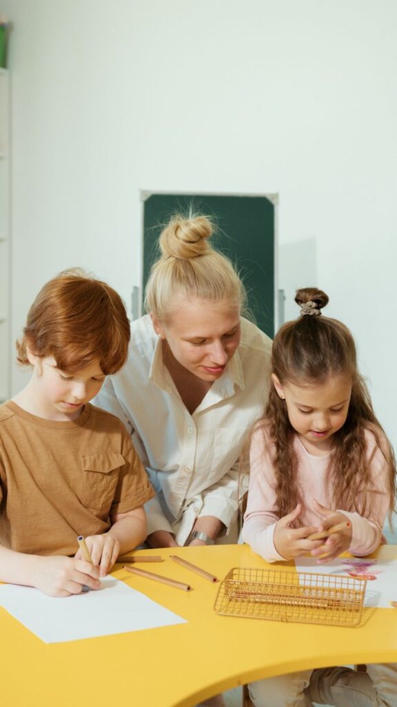 Teacher assists children in a classroom with learning activities.